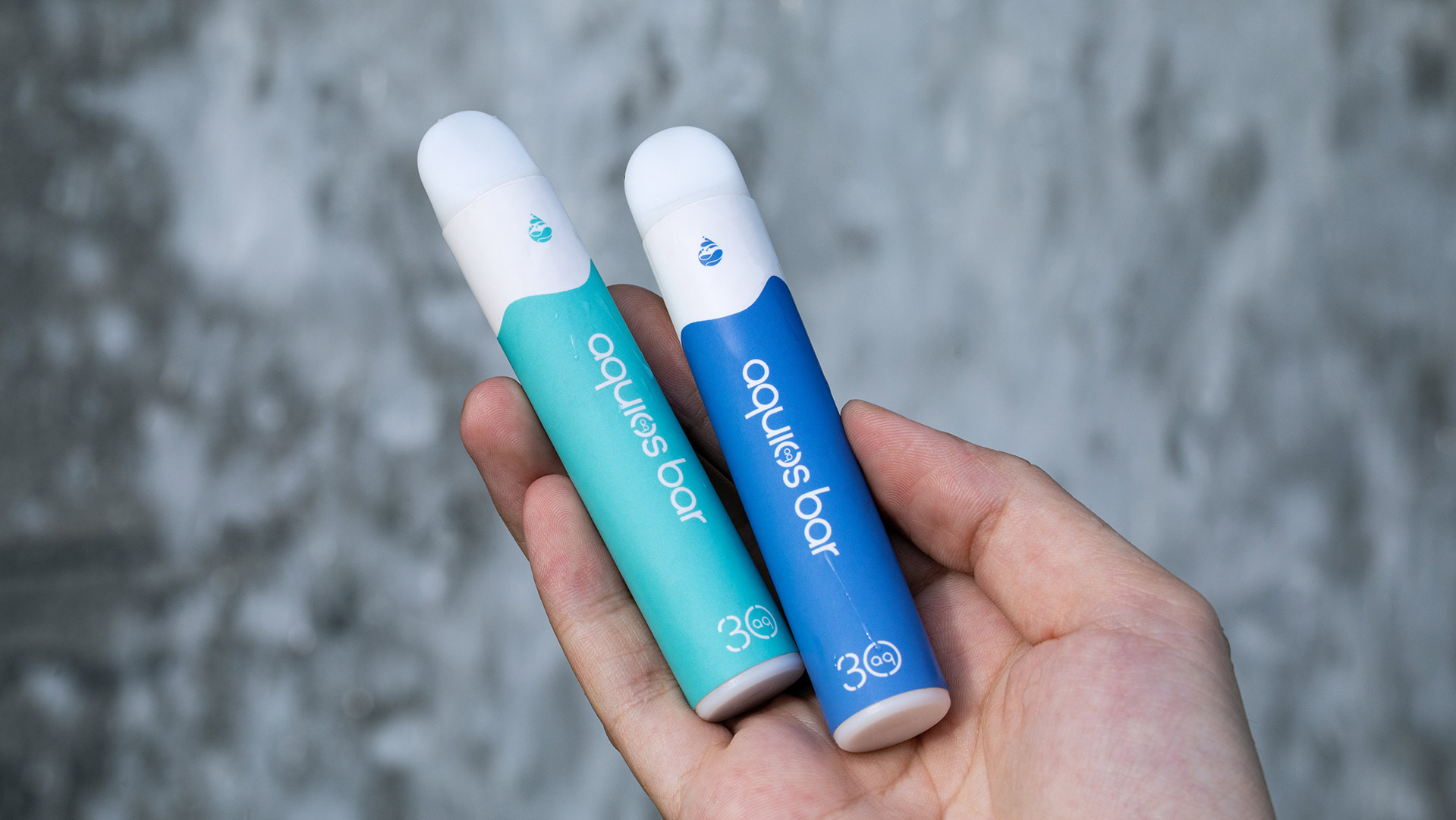 Hand holding two disposable vape pens, demonstrating the design and functionality of disposable vapes.