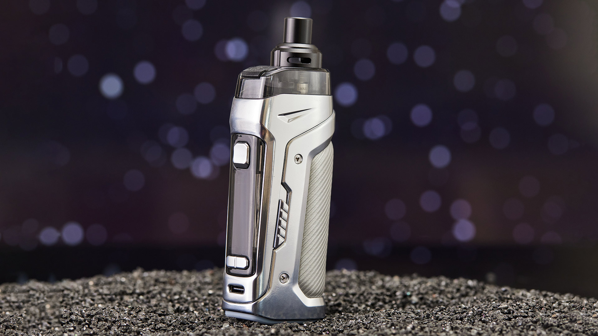 Innokin Coolfire PZPulse pod vape in a sleek silver design, standing on a textured black surface with a bokeh background.