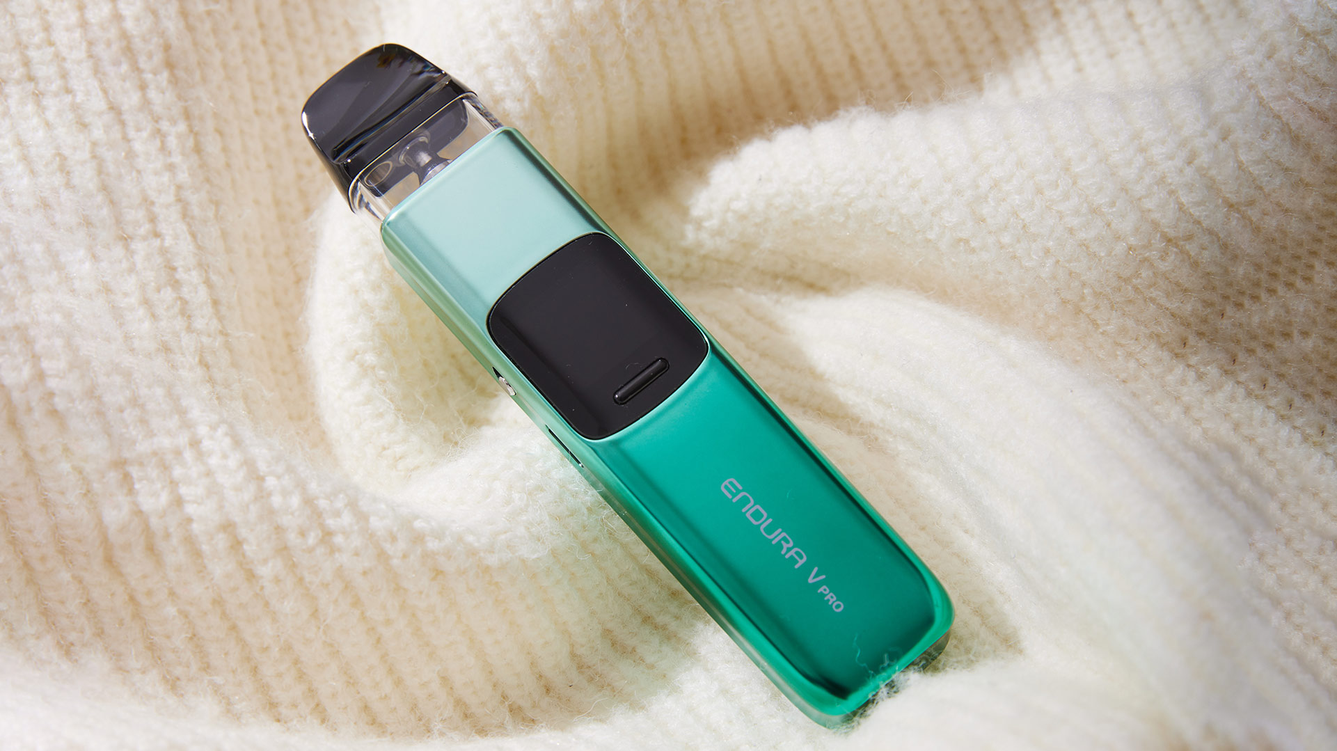 Innokin Endura V Pro pod vape in a vibrant green finish, resting on a soft knitted fabric background.
