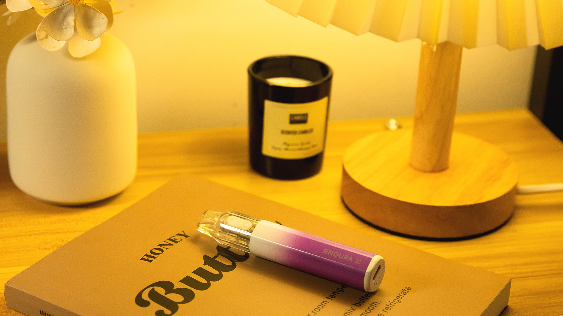 The Innokin Trine and Innokin Endura V refillable pod vapes hover above a smooth stone illuminated with pink light, set against a serene light blue background. The scene evokes a calm, contemplative atmosphere while posing the question: how long does a refillable vape last?