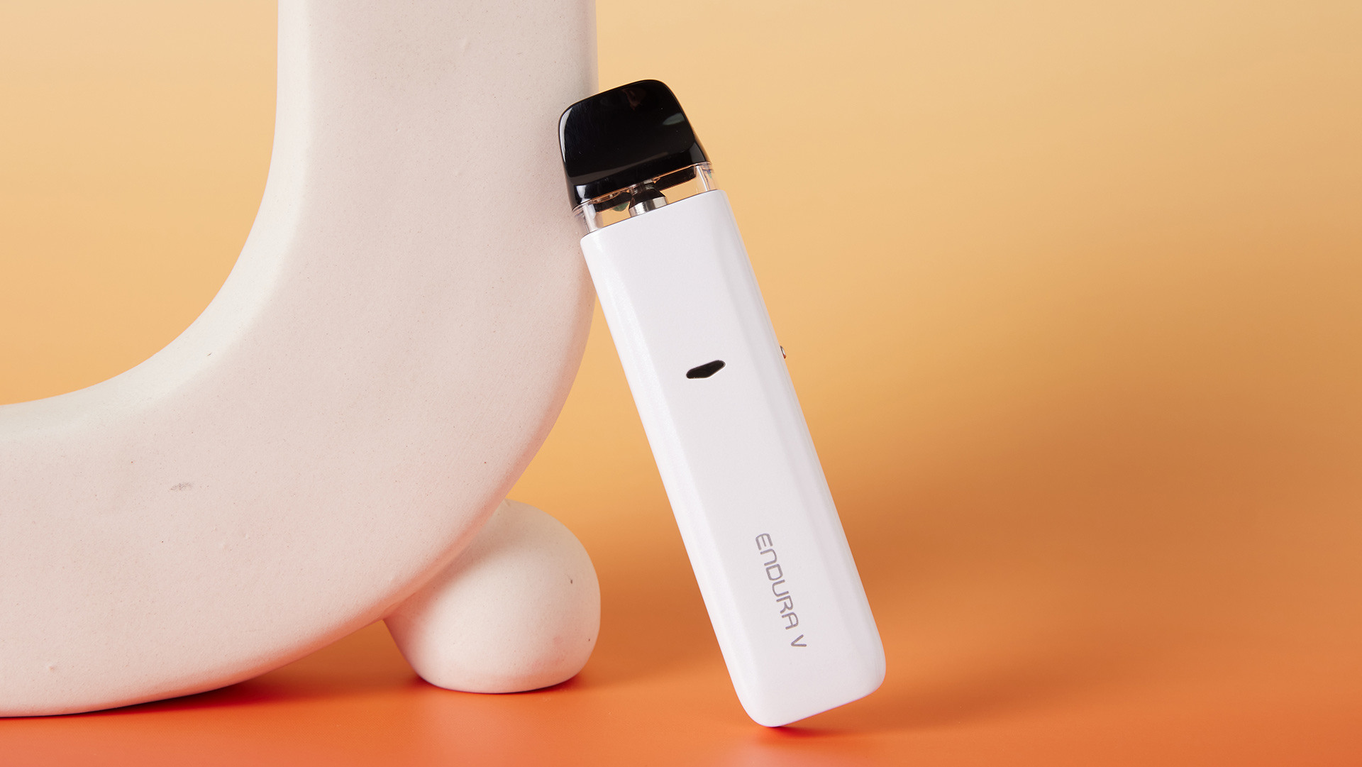 White Innokin Endura V electronic device leaning against a light-colored circular object.