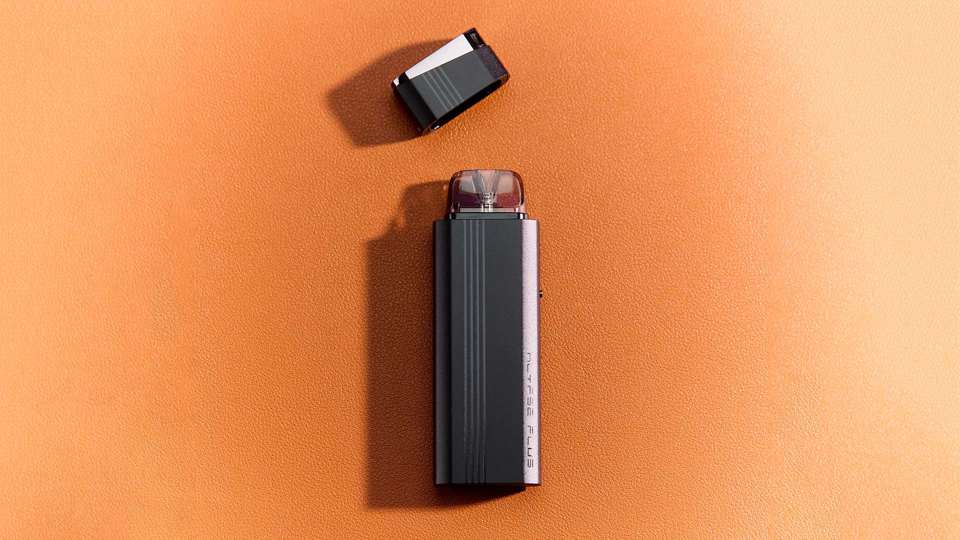 Klypse Plus pod vape system on an orange background, showcasing its sleek design.